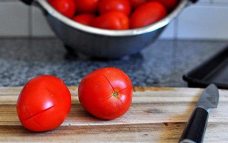
در اولین مرحله بعد از شستن گوجه فرنگی ها ،دو سر گوجه را با چاقو به صورت علامت ضربدر برش سطحی ای ایجاد کنید . این برش باعث می شود تا کمی بعد تر بتوانید به راحتی پوست گوجه ها را بکنید.